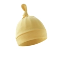 Close-up of yellow cotton newborn baby hat with soft knotted top and ribbed cuff detail - Chick Yellow