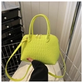 Detail of neon green crocodile texture shell bag with golden hardware and adjustable strap - Yellow