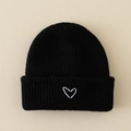 Detail of black knit beanie featuring a white embroidered heart on the front cuff - Hat / Black