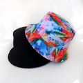 Detail showing reversible bucket hat with black solid side and colorful feather print fabric - Colorful Feather Pattern