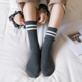 Grey cotton mid-calf socks with white stripes and ribbed texture in a lifestyle setting - Double Stripe Socks (Dark Grey)