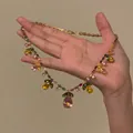 Détail du collier en or avec pendentif goutte rose et petites pierres multicolores - Or-Coloré-Fleur