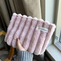 Handgehaltene Ansicht der weichen rosa Plüsch Kosmetiktasche mit Streifenstruktur und Etikett - Rosa