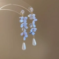 Dettaglio di orecchini floreali con petali viola e perle a goccia bianche - Stile Nappa Fiore Blu Sfumato / Oro-Blu