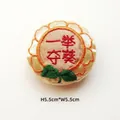 Detail of 5.5cm round Chinese embroidery patch with success text and floral edges - Win in One Go / Adjustable