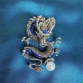 Vintage Silber Drachenbrosche mit blauen Strasssteinen und Perle auf blauem Stoff - Saphirblauer Gewundener Drache