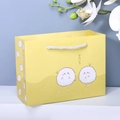 Gelbe Geschenktüte aus Papier mit weißem Griff und niedlichem Comic-Monster-Motiv - Gelber Schafball
