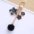 Llavero de flores con pompón negro y colgante letra D en metal dorado fino - Negro