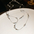 Détail d'un collier plaqué or avec perles blanc grisâtre et perles en métal argenté - Argenté