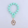 Detail of mint green silicone beaded wristlet with rhinestone rings and gold metal keychain - Mint Green