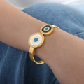 Gold open bangle featuring black and white evil eye discs on polished stainless steel - Gold Color (Z296)