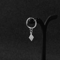 Dettaglio di orecchini d'argento con pendente a rombo geometrico su un supporto per gioielli - Stile Clip-on Argento (1 pezzo)