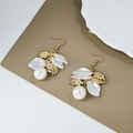 Detalle de pendientes de flores doradas vintage con pétalos blancos y perlas elegantes - Flor