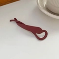 Detail einer matt dunkelroten Bananenspange für Haare auf einer weißen Oberfläche - Burgunderrot