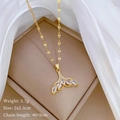 Detail view of gold whale tail zircon pendant on beige cushion with size and weight info - Gold Whale Tail Style (C324)