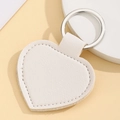Macro detail of a white heart-shaped leather keychain with a polished silver metal ring - Heart Shape / White