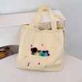 Detail view of cream canvas tote bag featuring colorful animal embroidery and drawstring - Off-white-Colorful Dog