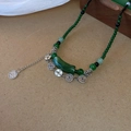 Detail einer Vintage-Perlenkette mit grünen Harzperlen und chinesischen Münzanhängern - Grüne Bambusknoten-Kupfermünzen-Halskette