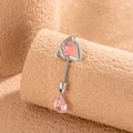 Silberner Bauchnabelpiercing mit rosa Dreieck und Tropfen-Zirkon auf beigem Grund - Linke Seite (Einzelstück)