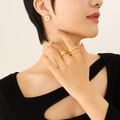 Golden jewelry set featuring bee earrings and textured rings worn by a female model - Gold Earrings