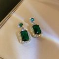 Detail of vintage emerald earrings with gold frame and sparkling diamond halo - Green Earrings