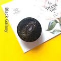 Detail of circular black galaxy phone grip with gold stars and glitter on card - Expanding Stand / Black Galaxy