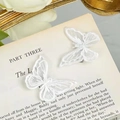 Paire de barrettes à cheveux papillon en dentelle brodée blanche sur une page de livre - Pince en Acier Papillon Blanc Double Couche 5*6cm