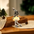 Detail of a glowing Christmas gnome ornament with a grey snowflake knitted hat and warm light - Grey Long Leg Style
