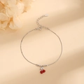 Elegante bracciale ciliegia in argento S925 con pendenti rossi su sfondo beige - Argento 925 / Oro Bianco