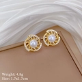 Macro-opname van titanium gouden spiraaloorbellen met parels en strass op witte zijde - Solar Spiraal Oorknopjes (D346) / Goud