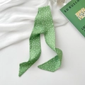 Polka dot green silk skinny scarf hair band tied around a decorative book background - Light Green Polka Dot