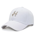 Minimalist white baseball cap featuring a golden embroidered letter H on the front - White