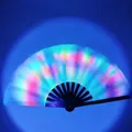 Macro shot of a light-up rainbow folding fan with black ribs and glowing fabric in dark - UV Fluorescent Rainbow Glow A31