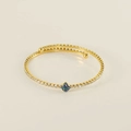 Macro detail of gold-plated bangle with blue square zircon and clear gemstone inlay - Blue Zirconia