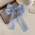 Vista de cerca del lazo para el pelo de organza azul claro con cintas largas - Azul