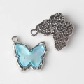 Detail of light blue resin butterfly pendant with silver star texture and hanging loop - Silver Base Blue