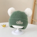 Detail der grünen Baby-Strickmütze mit zwei weißen Pompons und weichem Innenfutter - 1-3 Jahre / Grün