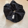 Close-up of striped bow scrunchie with Happiness label on a textured beige rug - Black Striped Bow Style / Black