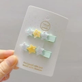 Close-up of two light green ribbon hair clips with glitter stars on a display card - 12# Green Base White Star Pair Clips