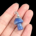 Blue crystal mushroom pendant with silver metal swirl cap held in hand on black background - Gun Black Cap / Blue Aventurine