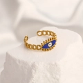 Golden evil eye chain ring with blue enamel detail on a white textured rock - Adjustable Open / 18K Gold Plated Evil Eye Blue