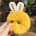 Bright yellow plush scrunchie with cute bunny ears on hand in street setting - 1128C Yellow Bunny Ears Plush Scrunchie