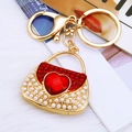 Golden handbag keychain with a large red heart gemstone and pearl bead accents - Red Pearl Heart Handbag Keychain