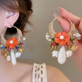 Detail of bohemian drop earrings with orange flowers, shell, and golden elephant pendants - Silver Earring Post Style / Gold-Coffee-White