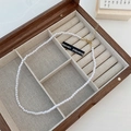 Detail of white pearl necklace with golden clasp in a wooden jewelry gift box - 4mm Pearl Style