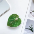 Macro shot of heart-shaped phone grip with green leaf pattern on white minimalist desk - Leaf Holder - Style 4