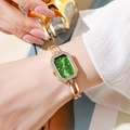 Close-up of gold quartz watch with emerald octagon dial and diamond-set bracelet - Green