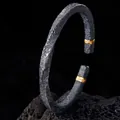 Vintage Mobius manchetarmband in antiek zwart met goudaccent en rotstextuur - Wisteria Tweekleurig