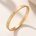 Bracelet jonc en acier titane doré avec gravure de pieds et fermoir sécurisé - Doré