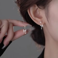 Silver bowknot stud earrings with dangling star charms shown on model's ear - Butterfly Bow Star Dangle (A253)